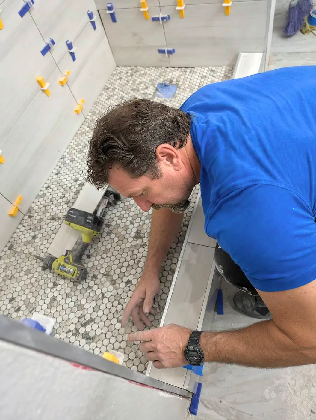 Handyman installing bathroom tile during home renovation project in Charlotte NC