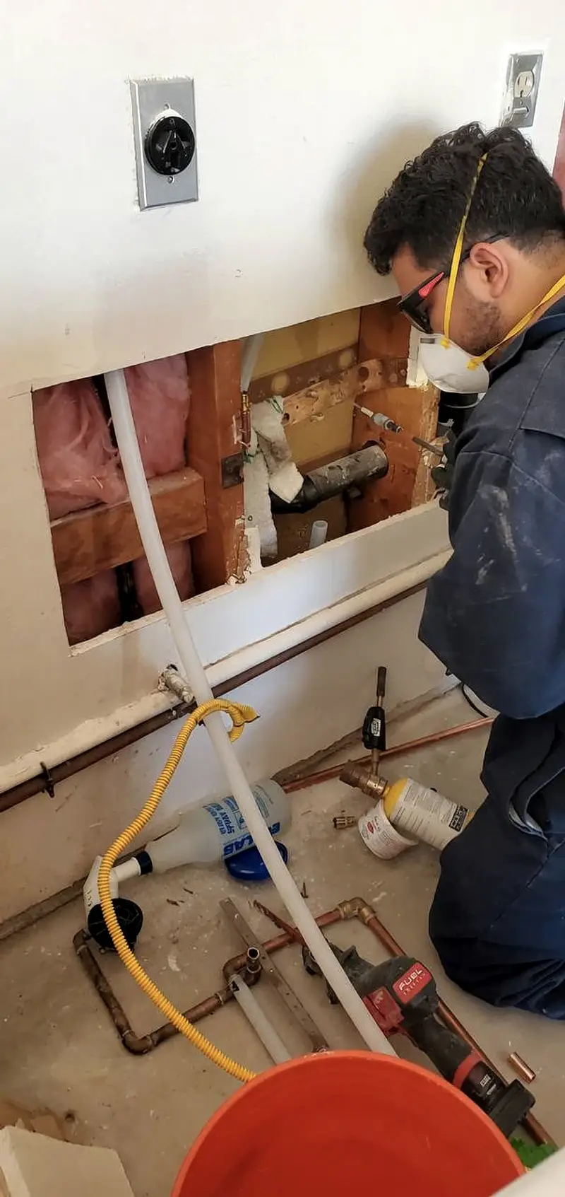 Plumber repairing a pipe leak in a Charlotte home